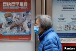 资料照：北京街头张贴鼓励老年人接种新冠疫苗的宣传画。（2022年3月30日）