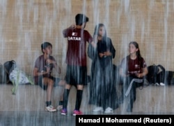 Piala Dunia Sepak Bola Anak Jalanan di Oxygen Park, Doha, Qatar, 11 Oktober 2022. Anggota tim Qatar di tengah hujan. (REUTERS/Hamad I Muhammad)