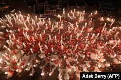 Lilin, spanduk, dan tebaran bunga saat para suporter sepak bola nasional berbelasungkawa kepada para korban tragedi Stadion Kanjuruhan, di Jakarta pada 2 Oktober 2022. (Foto: AFP/Adek Berry)