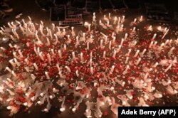 Lilin, spanduk, dan taburan bunga saat para suporter sepak bola nasional berbelasungkawa kepada para korban tragedi Stadion Kanjuruhan, di Jakarta pada 2 Oktober 2022. (Foto: Adek Berry/AFP)