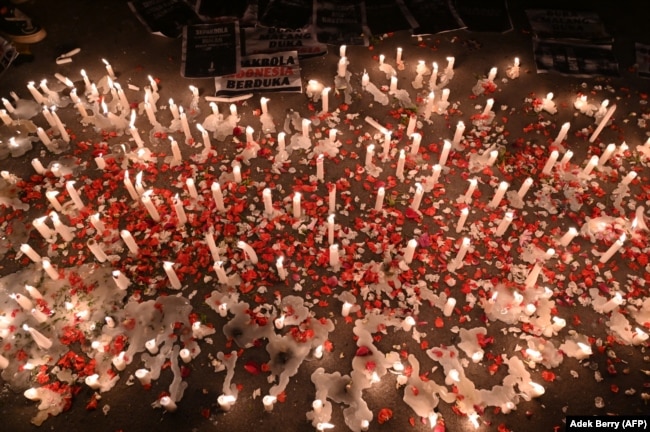 Lilin, spanduk, dan tebaran bunga saat para suporter sepak bola nasional berbelasungkawa kepada para korban tragedi Stadion Kanjuruhan, di Jakarta pada 2 Oktober 2022. (Foto: AFP/Adek Berry)
