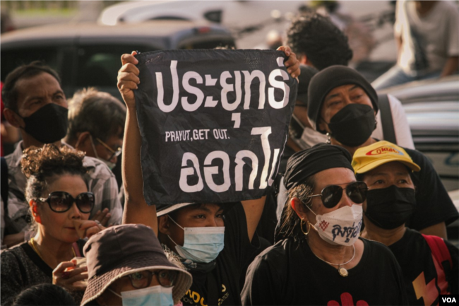 A protester holds up a sign directed against Thailand’s Prime Minister Prayut Chan-o-Cha during Saturday's anti-government demonstrations in Bangkok, Thailand, Oct. 1, 2022, (Tommy Walker/VOA)