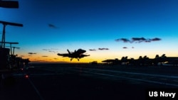 资料照片：在日本海，一架F/A-18F超级大黄蜂战斗机降落在美国海军里根号航空母舰的甲板上。(2022年10月5日)