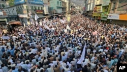 People take part in a protest rally to condemn the killing of a school van driver by a gunman in a Monday attack and demanding the immediate arrest of the attacker, in Mingora, Swat Valley, Pakistan, Oct. 11, 2022. 