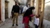 Seorang polisi bertugas mengawal petugas kesehatan saat memberikan vaksin polio kepada seorang anak di Peshawar, Pakistan, Senin, 24 Oktober 2022. (AP/Muhammad Sajjad)