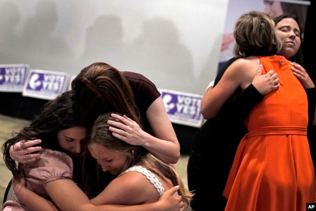 FILE - People hug after a referendum to remove abortion protections from the constitution of the state of Kansas failed, Aug. 2, 2022, in Overland Park, Kansas. (AP Photo/Charlie Riedel, File)