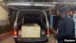 A wooden coffin containing the body of Pakistani journalist Arshad Sharif is loaded into a van at the Chiromo mortuary in Nairobi, Kenya, Oct. 24, 2022. 
