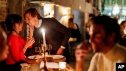 A couple speak as they enjoy a drink and candle lit dinner at Brasserie Surrealiste in Brussels, Sept. 28, 2022.
