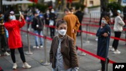 People wait in line to get tested for the coronavirus, in Jing'an district, Shanghai, China, Oct. 25, 2022.