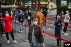 FILE - People wait in line to get tested for the coronavirus, in Jing'an district, Shanghai, China, Oct. 25, 2022.
