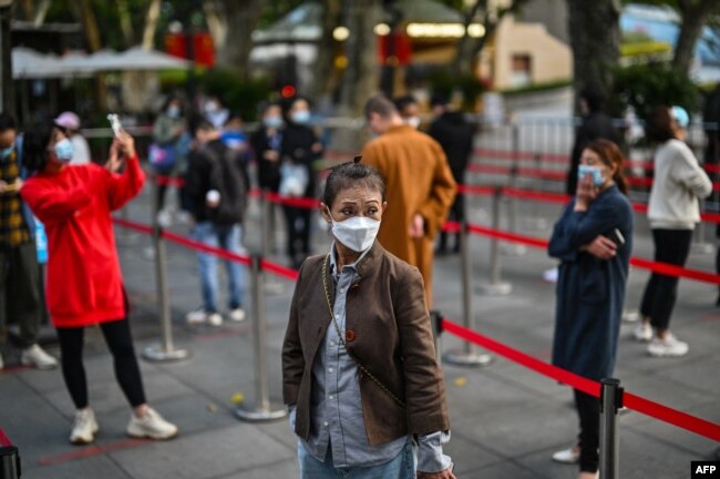 FILE - People wait in line to get tested for the coronavirus, in Jing'an district, Shanghai, China, Oct. 25, 2022. (Photo by Hector RETAMAL / AFP)