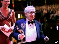 FILE - Leslie Jordan carries his award for outstanding guest actor in a comedy series, for his work on "Will & Grace," off stage during the Creative Arts Emmy Awards in Los Angeles, Aug. 19, 2006.