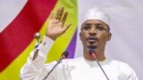 Mahamat Idriss Deby lève la main alors qu'il prête serment en tant que président de transition du Tchad, à N'Djamena le 10 octobre 2022.