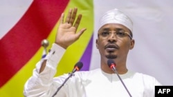 Mahamat Idriss Deby lève la main alors qu'il prête serment en tant que président de transition du Tchad, à N'Djamena le 10 octobre 2022.