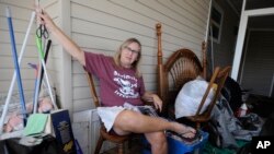 Brenda Palmer is surrounded by belongings from her mobile home, which filled with floodwaters from Hurricane Ian, in Fort Myers, Fla., on Oct. 9, 2022.