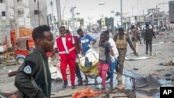 Rescuers remove a body from the scene of a double car bomb attack in Mogadishu, Somalia, Oct. 29, 2022.