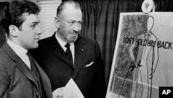 FILE — Nobel prize-winning author John Steinbeck, right, admires a prize-winning poster by his son, Thomas, in Hartford, Conn., March 22, 1963. A letter the author penned to his teenage son, offering fatherly advice about love, is going up for auction.