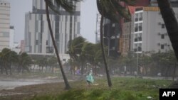 A man walks along the beach following the passage of typhoon Noru in Danang on September 28, 2022. 