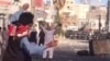 This screen grab from a UGC video posted on Oct. 28, 2022, purports to show demonstrators gesturing and throwing objects as they confront security forces during a protest in the southeastern Iranian city of Zahedan.