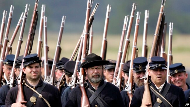 FILE — Re-enactors portraying the Union army's 20th Main, march during the 23rd Annual Gettysburg Civil War Heritage Days, in Gettysburg, Pa., June 25, 2005. Some historical battle re-enactors in New York are holding their musket fire because of worries over the state's new gun law.