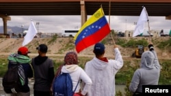 Migrantes venezolanos, algunos expulsados de EEUU a México bajo el Título 42 y otros que aún no han cruzado, protestan por las nuevas políticas migratorias a orillas del río Bravo, en Ciudad Juárez, México, el 18 de octubre de 2022. 