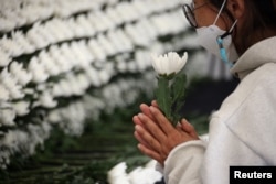 A person pays their respects at a group memorial altar for victims of a stampede that happened during Halloween festivities, in Seoul, South Korea, Oct. 31, 2022.