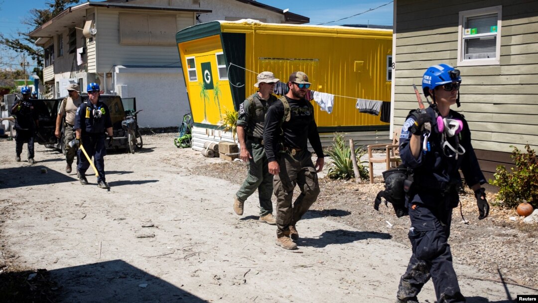 Federal Emergency Management Agency personnel and Lee County Sheriff officers walk through a trailer park after Hurricane Ian caused widespread destruction, in Fort Myers Beach, Florida, Oct. 3, 2022.