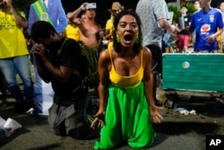 Supporters of Brazilian President Jair Bolsonaro react to results after polls closed in a presidential runoff election, in Rio de Janeiro, Oct. 30, 2022. Brazil's electoral authority announced that former President Luiz Inacio Lula da Silva had defeated Bolsonaro to become the country's next president.