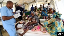 FILE - A nurse attends to mothers whose children are suffering malnutrition in a clinic set up by health authorities in collaboration with Medecins Sans Frontieres or Doctors Without Borders in Katsina State, northwest Nigeria, on July 20, 2022.