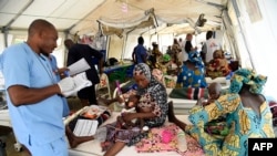 FILE - A nurse attends to mothers whose children are suffering malnutrition in a clinic set up by health authorities in collaboration with Medecins Sans Frontieres or Doctors Without Borders in Katsina State, northwest Nigeria, on July 20, 2022.