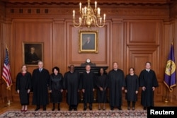 U.S. Supreme Court Chief Justice John Roberts and Associate Justice Ketanji Brown Jackson are flanked by fellow justices as they pose prior to Justice Jackson's investiture ceremony at the Supreme Court in Washington, September 30, 2022.