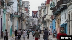 Una bandera cubana se exhibe en lo alto entre dos edificios en una calle La Habana, la capital de Cuba, el 26 de julio de 2021.