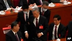 2022年10月22日，在北京人民大会堂举行的中国执政的共产党第20次全国代表大会闭幕式上，中国前国家主席胡锦涛（中）被护送离开。