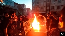 FILE - In this Sept. 21, 2022, photo taken by an individual not employed by The Associated Press and obtained by the AP outside Iran, protesters block the street during a protest over the death of a woman detained by the morality police, in downtown Tehran, Iran.