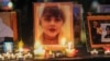 FILE - Candles and pictures of Mahsa Amini are shown during a vigil in Los Angeles for Mahsa Amini, who died in custody of Iran's morality police, Sept. 29, 2022. 