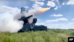 This handout photo taken from video released by Russian Defense Ministry Press Service on Sunday, Oct. 16, 2022, shows the Russian military's short-range tactical surface-to-air missile system Osa firing rockets at Ukrainian troops at an undisclosed location.