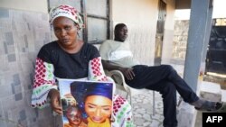 Mariama Kuyateh, 30 ans, brandit une photo de son défunt fils Musa, décédé d'une insuffisance rénale aiguë, à Banjul le 10 octobre 2022.