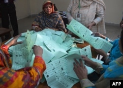 Petugas pemilu Pakistan menghitung surat suara pada akhir pemungutan suara di Islamabad pada 11 Mei 2013. (Foto: AFP)