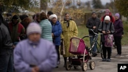 La gente espera en la fila mientras se distribuye la ayuda humanitaria en la aldea de Mykhailo Lukasheve, en la región de Zaporizhzhia, Ucrania, el 20 de octubre de 2022.