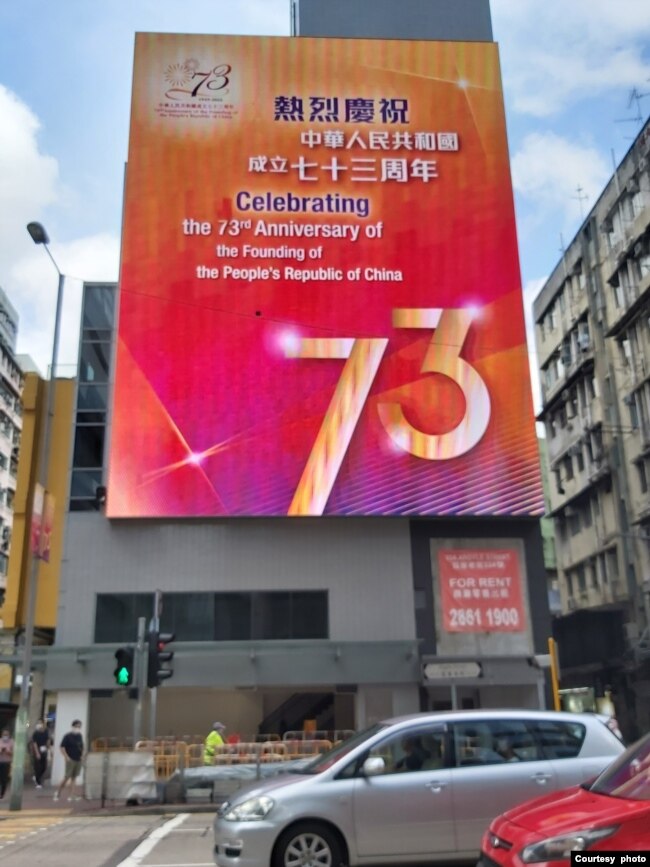 香港街头悬挂的庆祝中华人民共和国成立73周年的巨幅广告。美国之音高鋒摄。