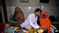 Children in hospital beds are treated after their family homes were hit by flooding in Sehwan, Sindh province, Pakistan, Friday, 9, 2022.
