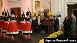 Vice President Kamala Harris, left in the doorway, President Joe Biden center, and first lady Jill Biden watch the Sa Dance Company perform at a reception to celebrate Diwali in the East Room of the White House in Washington, D.C., on Oct. 24, 2022. 