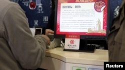 A sign of China's digital yuan, or e-CNY, is seen during a trial of the Digital Currency Electronic Payment (DCEP) at a store in Beijing. Central banks are seeking ways to digitize currency. (REUTERS/Florence Lo)