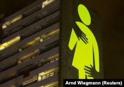 Sebuah proyeksi cahaya terlihat saat aksi protes kelompok hak-hak perempuan Amnesty International terhadap kekerasan seksual dan KDRT dalam rangka Hari Perempuan Internasional di Zurich, Swiss 7 Maret 2021. (Foto: REUTERS/Arnd Wiegmann)