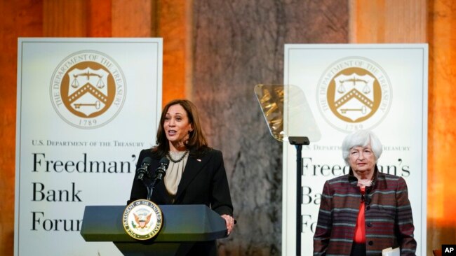 FILE - US Vice President Kamala Harris speaks during the Freedman Bank Forum as Treasury Secretary Janet Yellen looks on in Washington, Dec. 14, 2021.