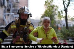 乌克兰救援人员在基辅帮助一名被俄国导弹袭击击伤的妇女。（2022年10月10日）