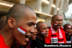 Suporter Indonesia meneriakkan yel-yel menjelang pertandingan babak kualifikasi Piala Dunia antara Indonesia dan Qatar, di Jakarta 11 Oktober 2011. (Foto: REUTERS/Beawiharta)