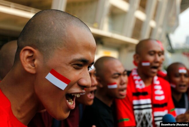 Suporter Indonesia meneriakkan yel-yel menjelang pertandingan babak kualifikasi Piala Dunia antara Indonesia dan Qatar, di Jakarta 11 Oktober 2011. (Foto: REUTERS/Beawiharta)