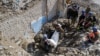 Ukrainian army soldiers and fire fighter extract the body of an army officer, who was found among the remains of the building beside the TV tower, in the recently liberated town of Izium, Kharkiv region, Sept. 29, 2022. 