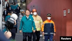 South Korean President Yoon Suk-yeol walks at the scene where many people died and were injured in a stampede during a Halloween festival in Seoul, South Korea, Oct. 30, 2022.